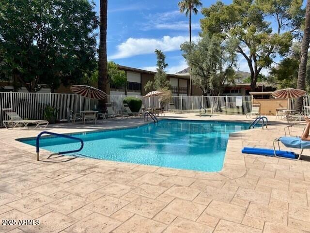 pool with a patio area and fence
