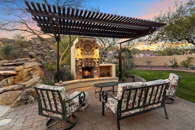 patio terrace at dusk featuring an outdoor living space with a fireplace