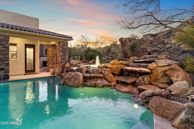 pool at dusk with pool water feature