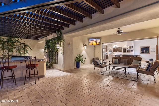 view of patio / terrace featuring exterior bar, outdoor lounge area, and ceiling fan