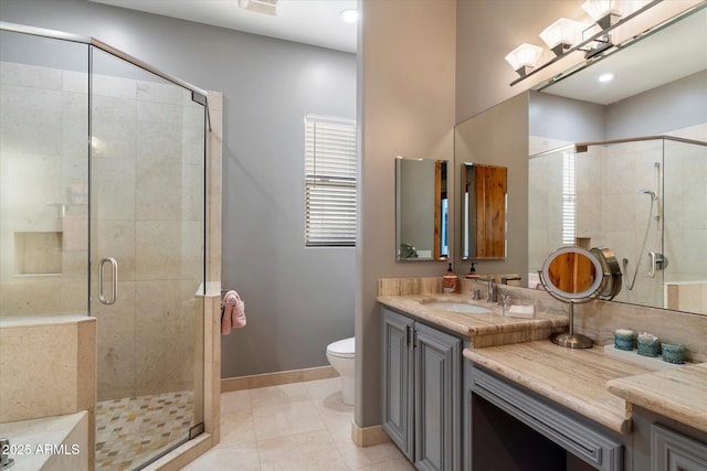 bathroom featuring tile patterned flooring, a shower with door, vanity, and toilet