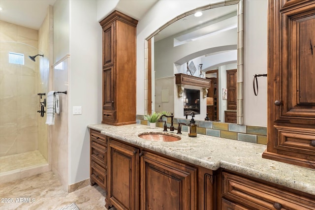 bathroom featuring a tile shower and vanity