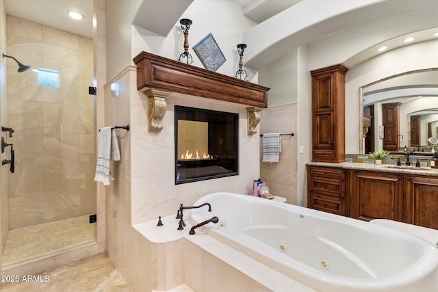 bathroom with vanity and shower with separate bathtub