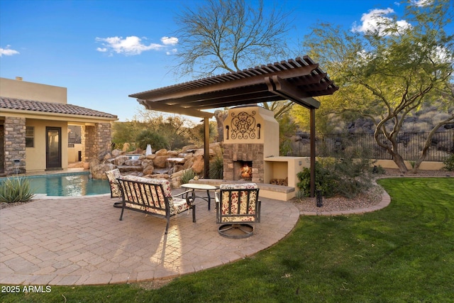 view of patio / terrace with an outdoor stone fireplace and a fenced in pool