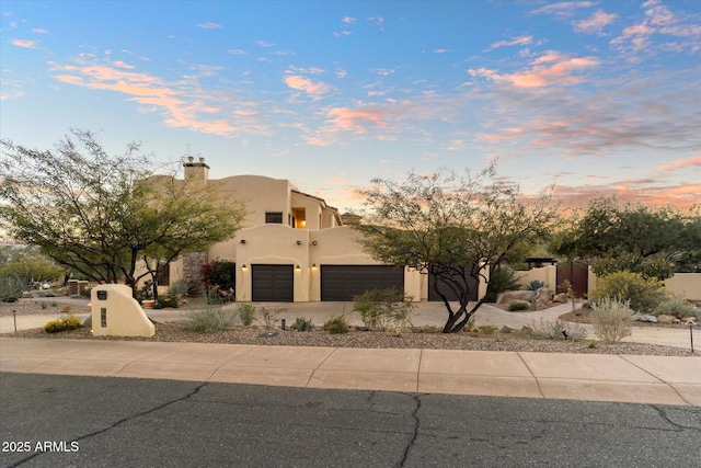 pueblo-style house featuring a garage