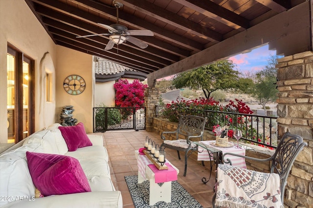 patio terrace at dusk with outdoor lounge area and ceiling fan