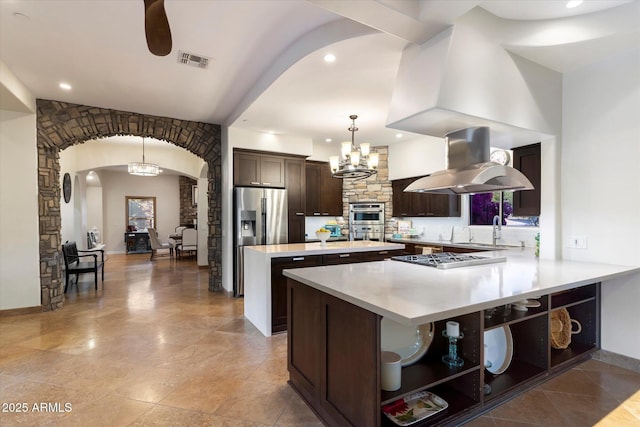 kitchen with decorative light fixtures, a kitchen island, dark brown cabinetry, island exhaust hood, and stainless steel appliances