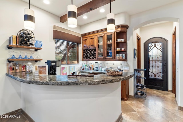 bar with decorative light fixtures, plenty of natural light, decorative backsplash, and dark stone counters