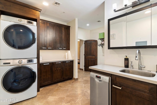 laundry area featuring stacked washer / drying machine and sink