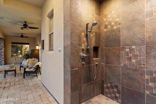 bathroom featuring ceiling fan and a tile shower