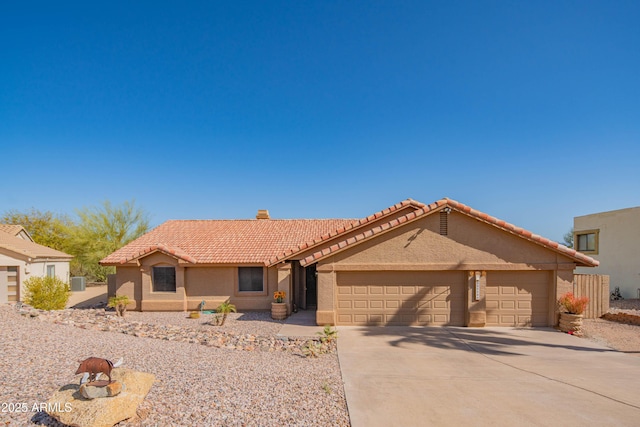 view of front of house featuring an attached garage, stucco siding, a chimney, concrete driveway, and a tile roof