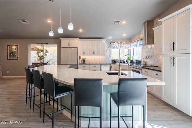 kitchen with white cabinetry, refrigerator, stainless steel electric stove, and visible vents