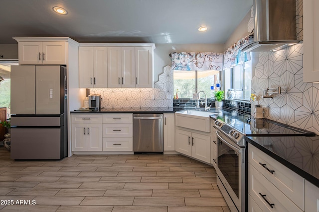 kitchen with a sink, dark countertops, appliances with stainless steel finishes, and white cabinets