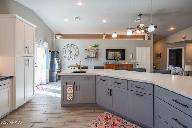 kitchen with a sink, visible vents, pendant lighting, and gray cabinets