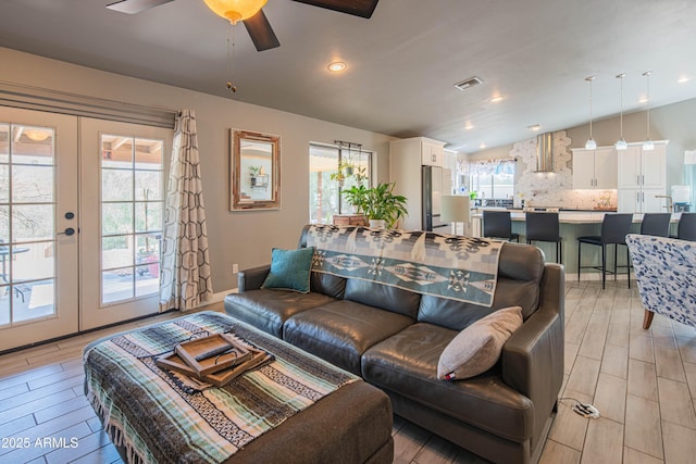 living room featuring visible vents, wood tiled floor, lofted ceiling, recessed lighting, and french doors