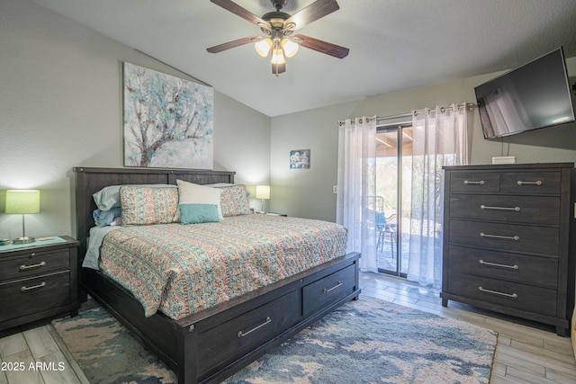 bedroom with wood finish floors, lofted ceiling, access to exterior, and ceiling fan