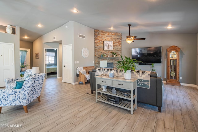 living room featuring visible vents, baseboards, lofted ceiling, and wood tiled floor