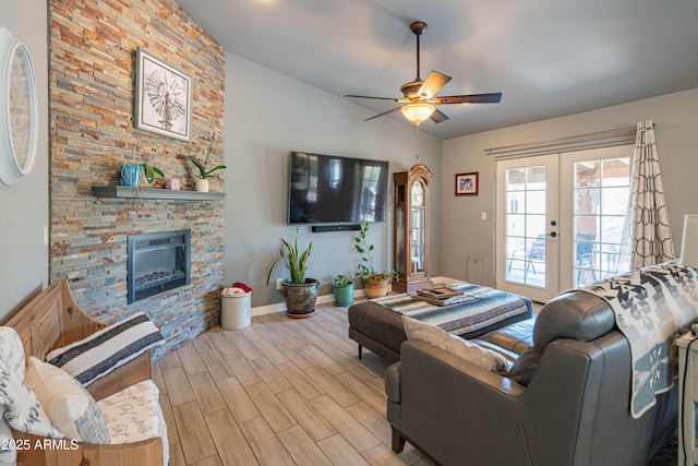 living room featuring wood finish floors, vaulted ceiling, french doors, a fireplace, and a ceiling fan