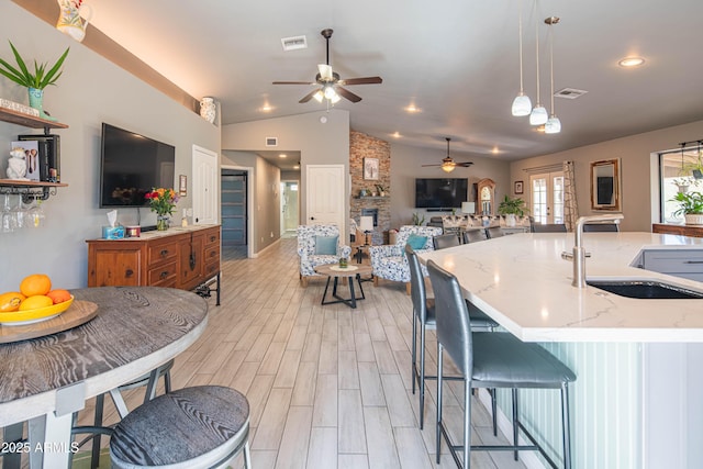 kitchen with a sink, visible vents, open floor plan, and french doors