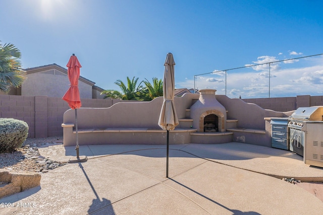 exterior space featuring a grill, an outdoor kitchen, and exterior fireplace