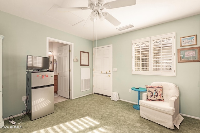 living area featuring ceiling fan and light colored carpet