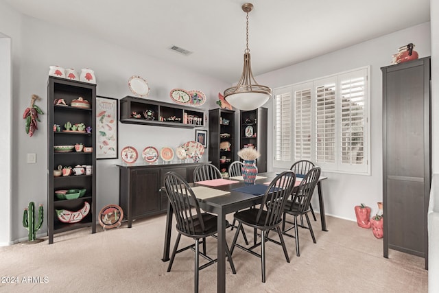 dining space featuring light carpet