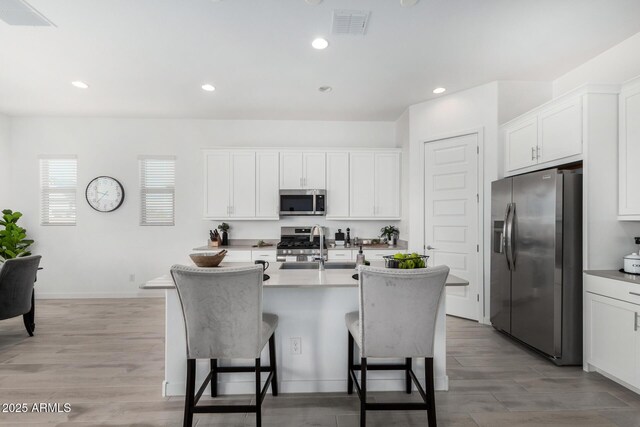 3089 N 200th Ave, Buckeye, AZ 85396 - kitchen with appliances with stainless steel finishes, a kitchen breakfast bar, a sink, a center island with sink, and white cabinets