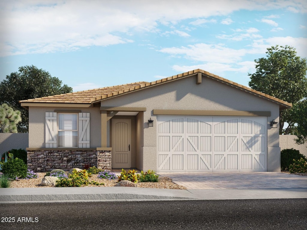 view of front of property with stone siding, a garage, driveway, and stucco siding