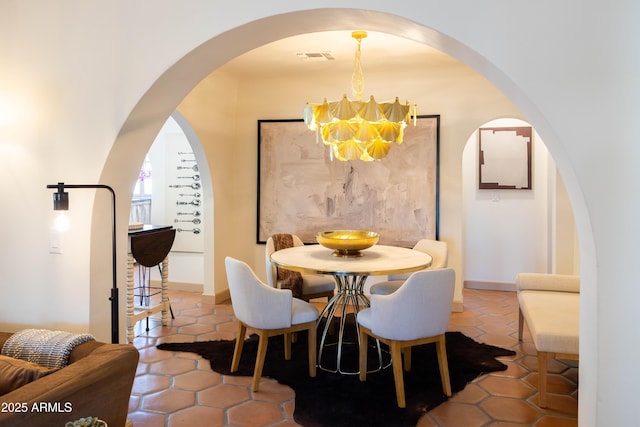 1309 W Lynwood St, Phoenix, AZ 85007 - dining space featuring a chandelier, tile patterned floors, arched walkways, and baseboards