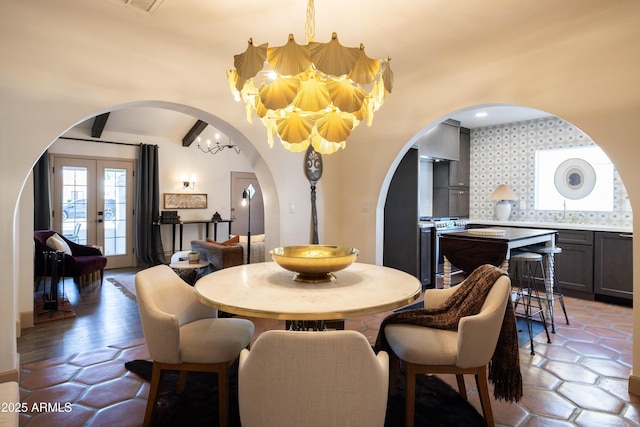 1309 W Lynwood St, Phoenix, AZ 85007 - dining space with arched walkways, a chandelier, and french doors