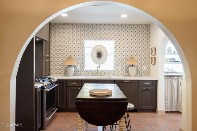 1309 W Lynwood St, Phoenix, AZ 85007 - kitchen featuring a sink, stainless steel gas range oven, tile patterned floors, light countertops, and backsplash