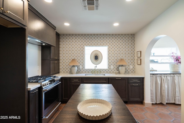 1309 W Lynwood St, Phoenix, AZ 85007 - kitchen with stainless steel gas range oven, a sink, backsplash, dark tile patterned flooring, and recessed lighting