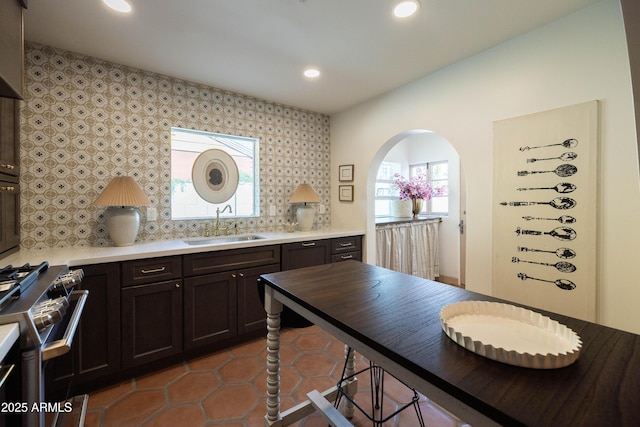 1309 W Lynwood St, Phoenix, AZ 85007 - kitchen with stainless steel gas range oven, a sink, recessed lighting, decorative backsplash, and tile patterned floors