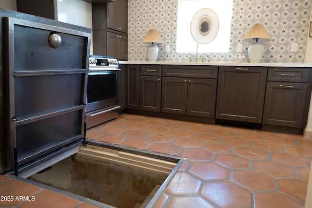 1309 W Lynwood St, Phoenix, AZ 85007 - kitchen featuring range, decorative backsplash, light countertops, and light tile patterned flooring