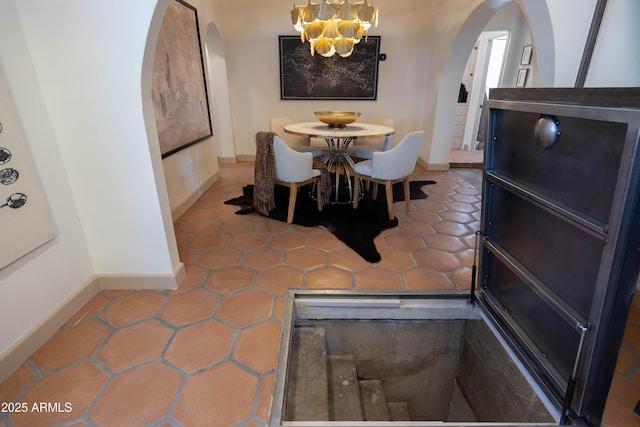 1309 W Lynwood St, Phoenix, AZ 85007 - dining space featuring arched walkways, a chandelier, baseboards, and tile patterned flooring