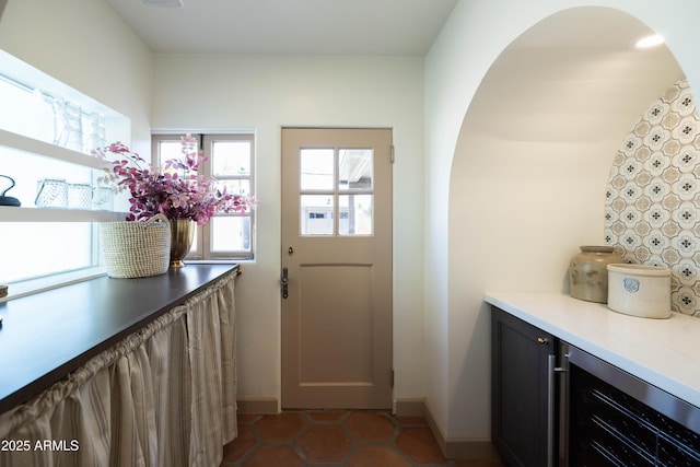 1309 W Lynwood St, Phoenix, AZ 85007 - doorway with beverage cooler, tile patterned floors, baseboards, and arched walkways