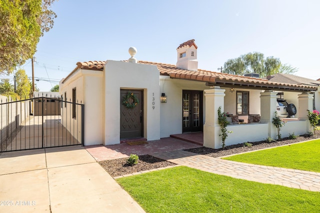 1309 W Lynwood St, Phoenix, AZ 85007 - mediterranean / spanish house featuring a tiled roof, a gate, stucco siding, and french doors