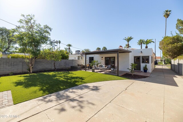 1309 W Lynwood St, Phoenix, AZ 85007 - back of house featuring an outdoor hangout area, stucco siding, concrete driveway, and a patio area