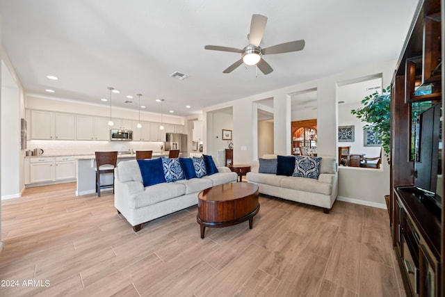 living room featuring light wood-type flooring and ceiling fan