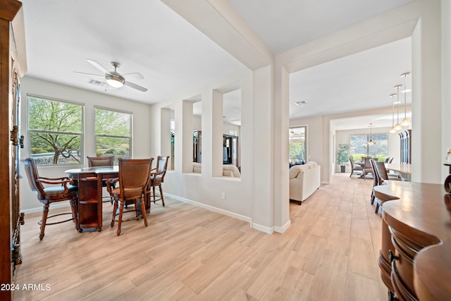 dining room with light hardwood / wood-style floors, ceiling fan, and plenty of natural light