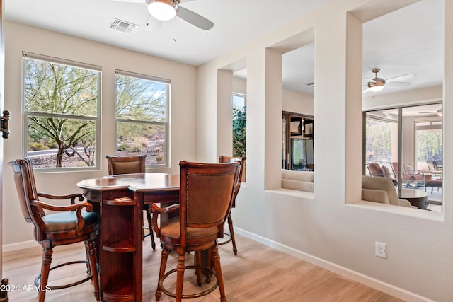 dining room with light wood-type flooring, ceiling fan, and plenty of natural light