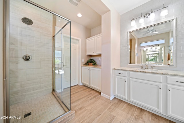 bathroom featuring vanity, hardwood / wood-style floors, ceiling fan, and a shower with shower door