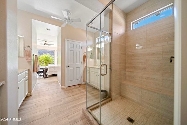 bathroom featuring ceiling fan, a shower with shower door, plenty of natural light, and vanity