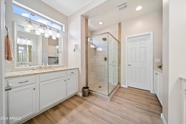 bathroom with hardwood / wood-style floors, an enclosed shower, and vanity