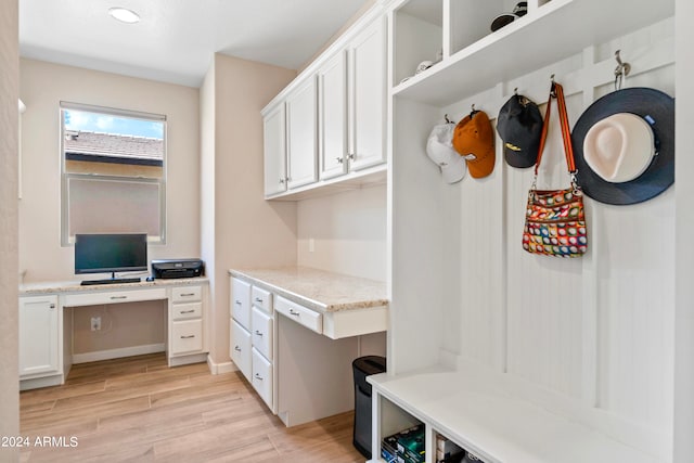 mudroom featuring built in desk and light hardwood / wood-style flooring