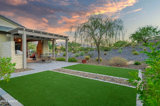 yard at dusk featuring a patio area