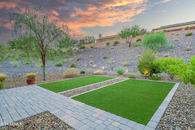 yard at dusk featuring a patio area