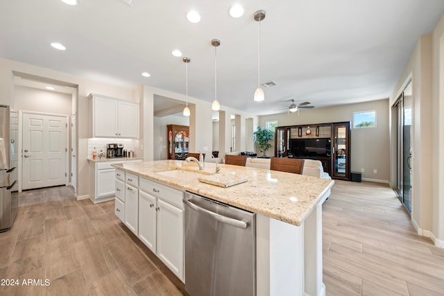 kitchen with ceiling fan, white cabinets, a kitchen island with sink, and appliances with stainless steel finishes