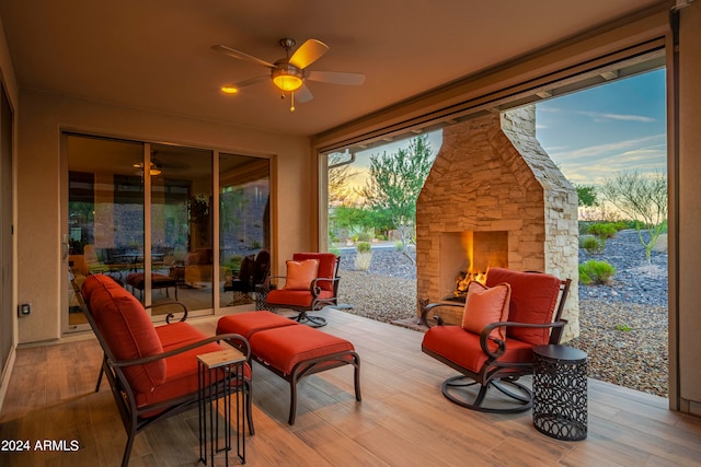 exterior space with ceiling fan, a healthy amount of sunlight, and an outdoor stone fireplace