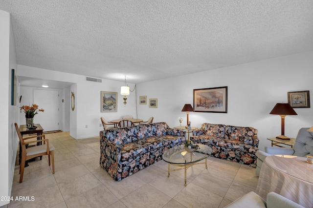 living room with a textured ceiling and light tile patterned flooring